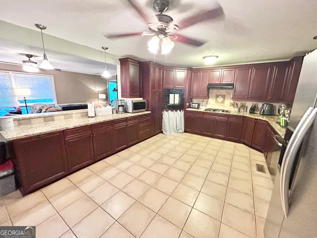 a large kitchen with kitchen island a sink stainless steel appliances and cabinets