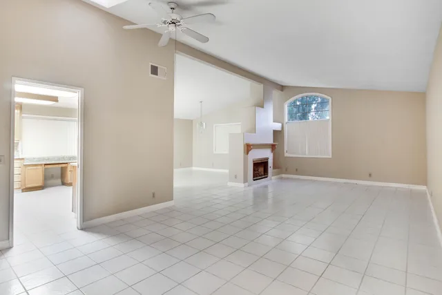 an empty room with windows and fireplace