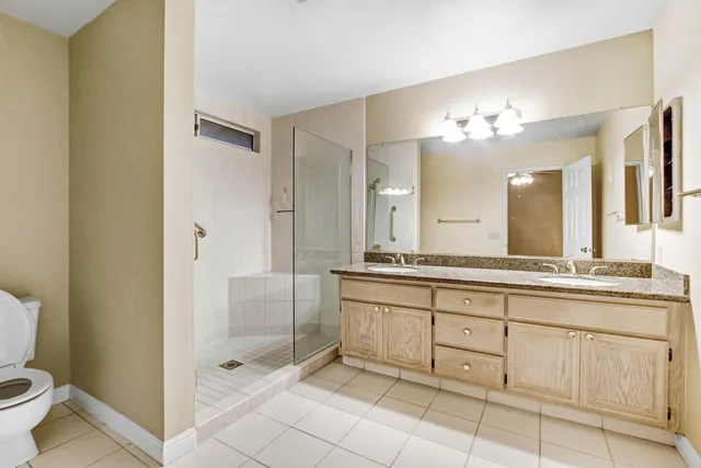 a spacious bathroom with a shower a sink and mirror