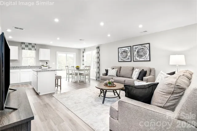 a living room with furniture and view of kitchen