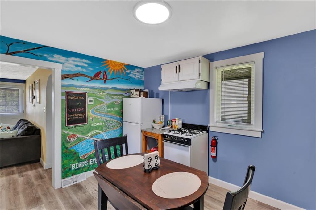 1646 Main Street Leechburg, PA 15656 - Photo 24 of 33 a kitchen with stainless steel appliances kitchen island granite countertop a table chairs in it and wooden floors