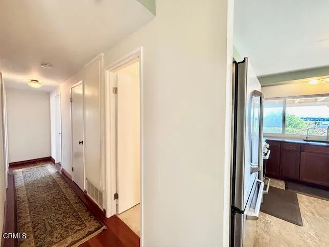 a view of a hallway with wooden floor and a glass door