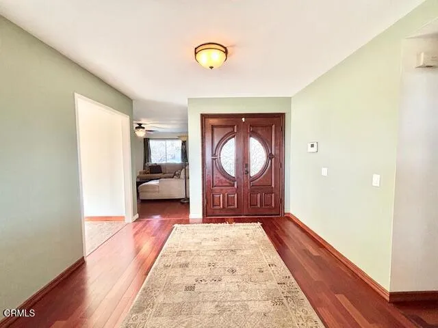 a view of hallway with wooden floor and furniture