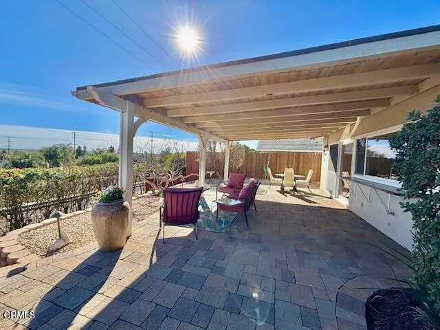a view of a patio with table and chairs potted plants with wooden floor and fence