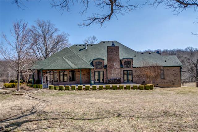 Rear view of home with large entertaining patio, beautiful views of large trees and pastures. Bring the horses!