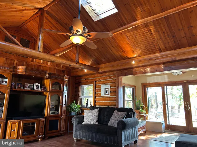 a living room with furniture a flat screen tv and a floor to ceiling window