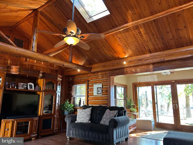 a living room with furniture a flat screen tv and a floor to ceiling window