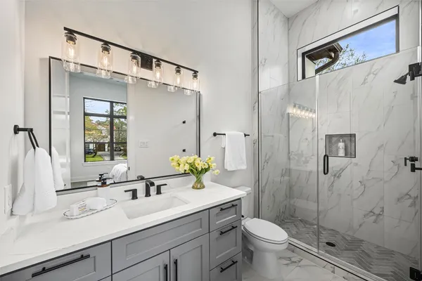 a spacious bathroom with a tub sink shower and mirror