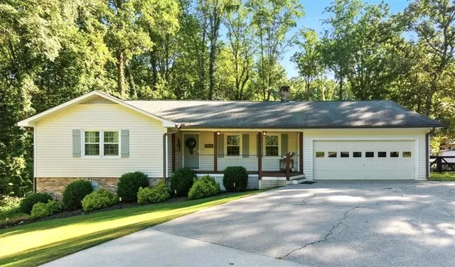 a view of a white house with a yard and plants