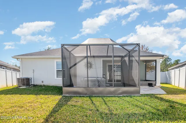 a view of a house with a big yard and a large tree