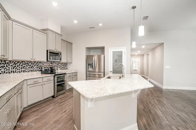 a kitchen with granite countertop a sink stove and refrigerator