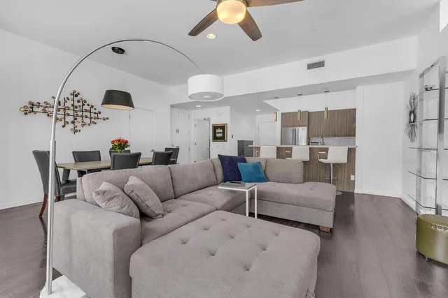 a living room with furniture a chandelier and a large window