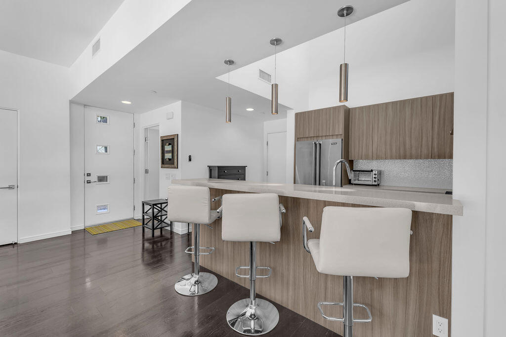 350 Goleta Way Palm Springs, CA 92264 - Photo 13 of 60 a kitchen with stainless steel appliances kitchen island granite countertop a table chairs and a refrigerator