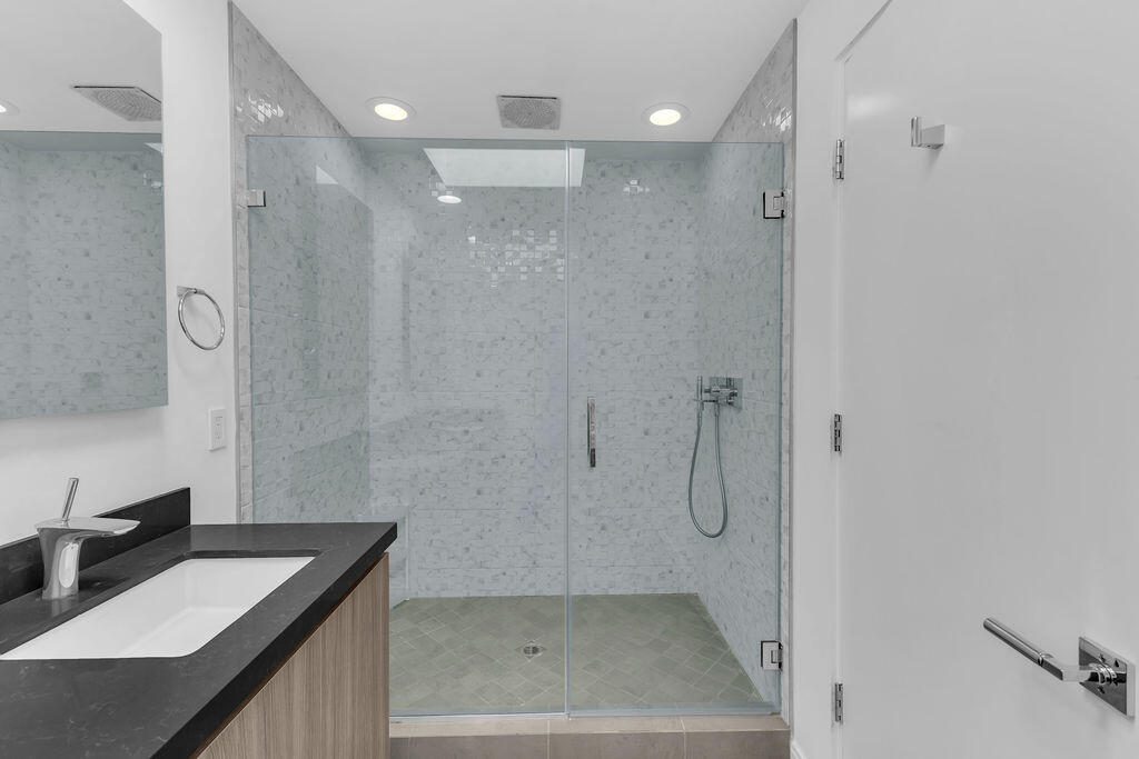 350 Goleta Way Palm Springs, CA 92264 - Photo 32 of 60 a bathroom with a granite countertop sink a shower and a mirror