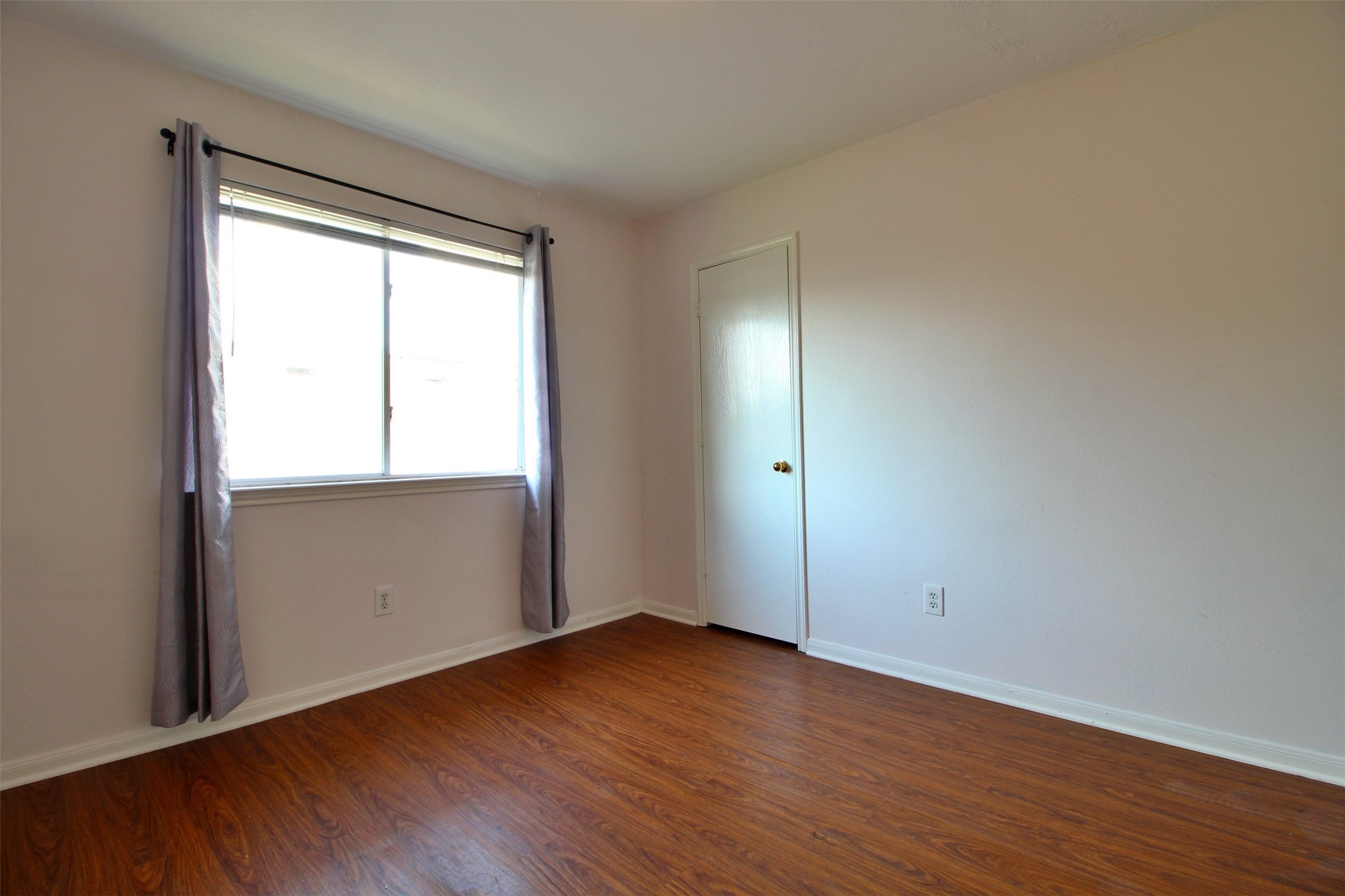 6803 Highwind Bend Lane Katy, TX 77449 - Photo 9 of 10 an empty room with wooden floor and windows