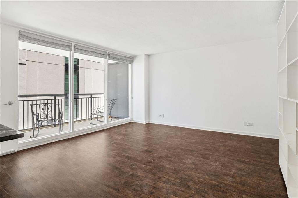 620 Peachtree Street Northeast, Unit 1716 Atlanta, GA 30308 - Photo 4 of 37 an empty room with wooden floor and windows