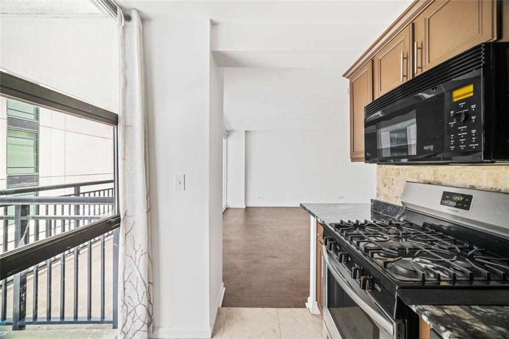 620 Peachtree Street Northeast, Unit 1716 Atlanta, GA 30308 - Photo 8 of 37 a kitchen with stainless steel appliances granite countertop a stove and a microwave