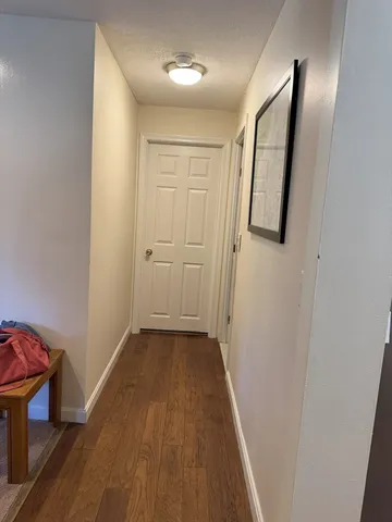 a view of a hallway with wooden floor and staircase