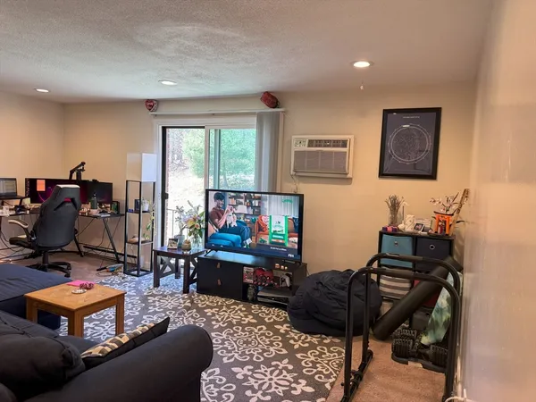a living room with furniture a flat screen tv and a window