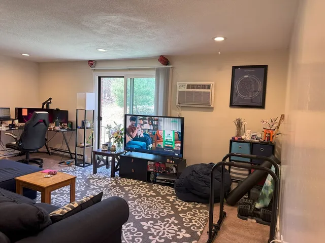 a living room with furniture a flat screen tv and a window