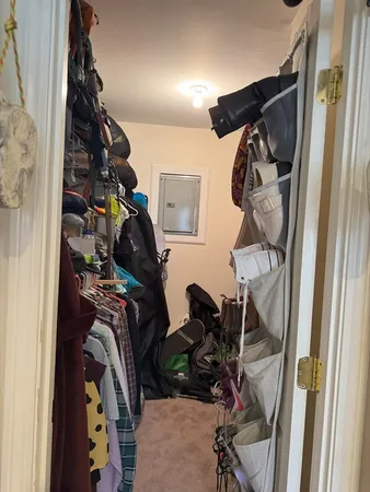 a view of walk in closet with clothes and shoes