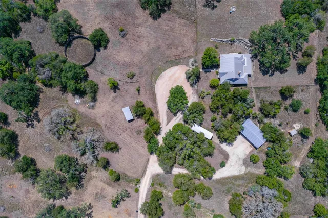 an aerial view of a house and a yard and a fountain