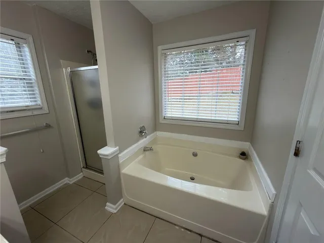 a bathroom with a tub sink and mirror