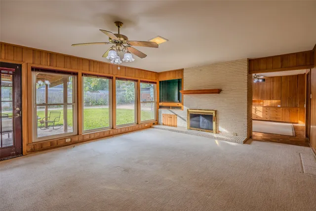 a view of an empty room with a fireplace and a window