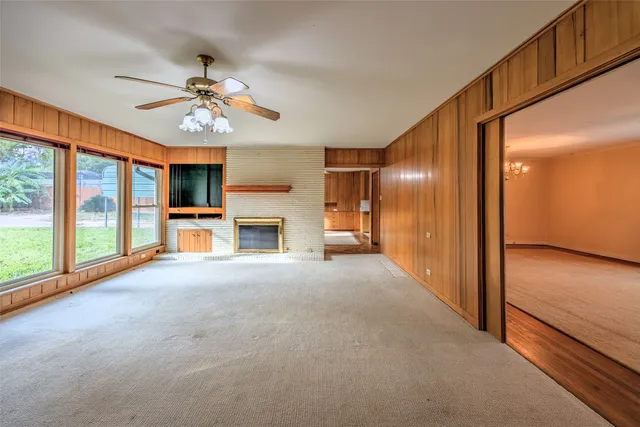 a view of empty room with a fireplace and fan