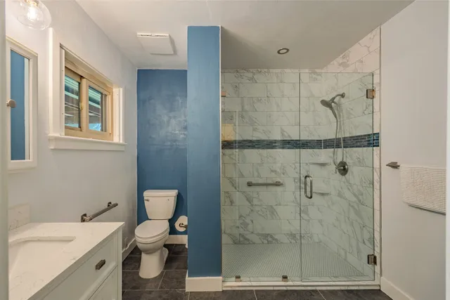 a bathroom with a sink a toilet and shower