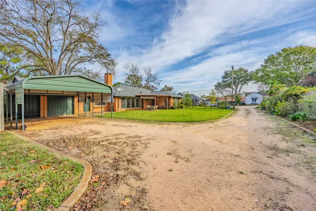 a view of a house with a yard and pathway