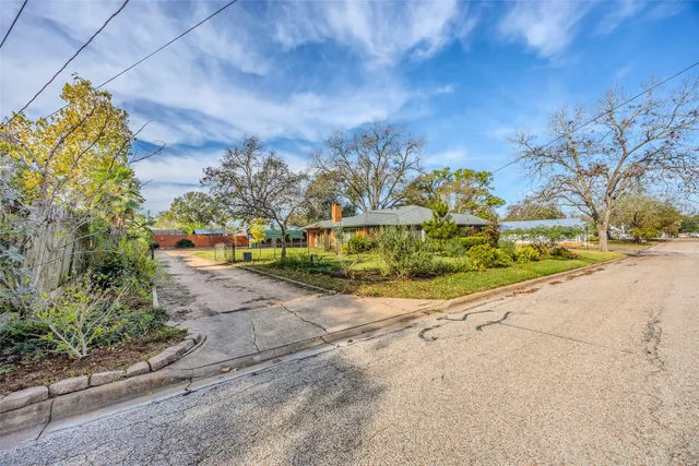 a view of a house with a big yard and large trees