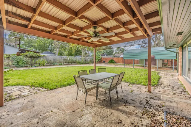 a view of a chair and table in backyard of the house