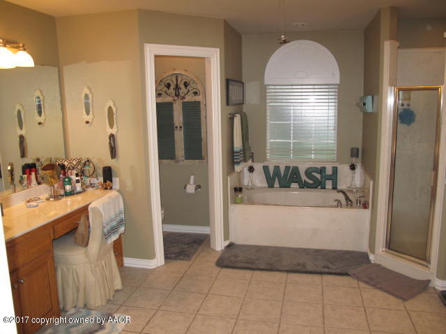 6606 Rally Road Amarillo, TX 79119 - Photo 16 of 20 a spacious bathroom with a tub and mirror