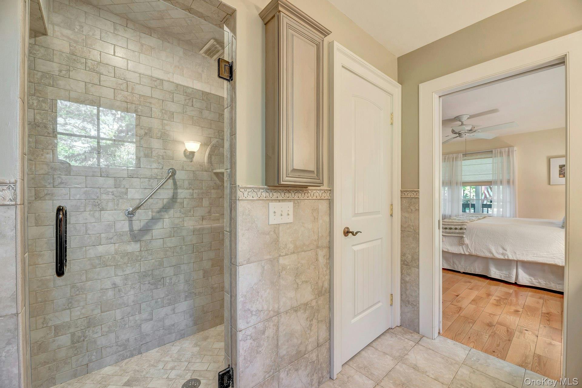 3600 Rocky Point Road East Marion, NY 11939 - Photo 18 of 45 Full bath featuring a stall shower, ensuite bath, tile walls, ceiling fan, and a wainscoted wall