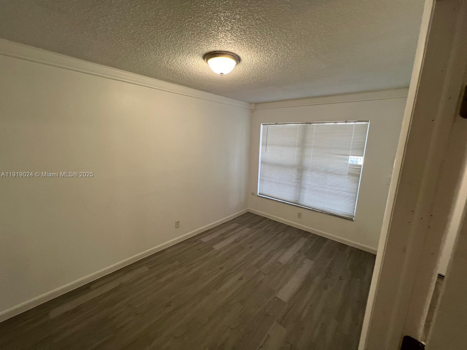 6840 Pembroke Road, Unit 112 Pembroke Pines, FL 33023 - Photo 3 of 5 an empty room with a empty space and windows