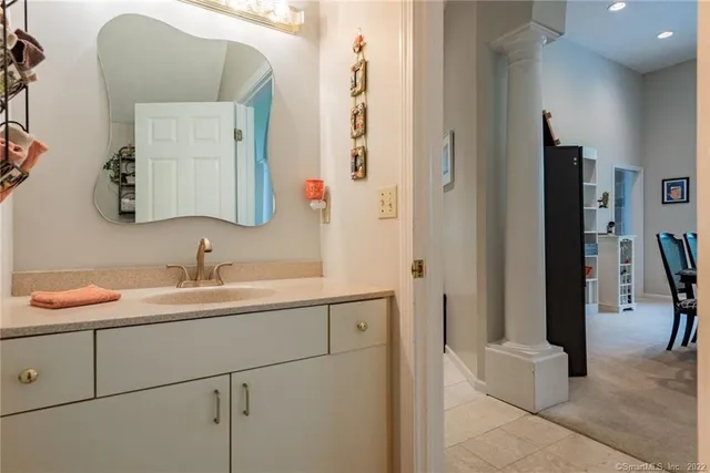 a bedroom with a bed and a lamp on dresser