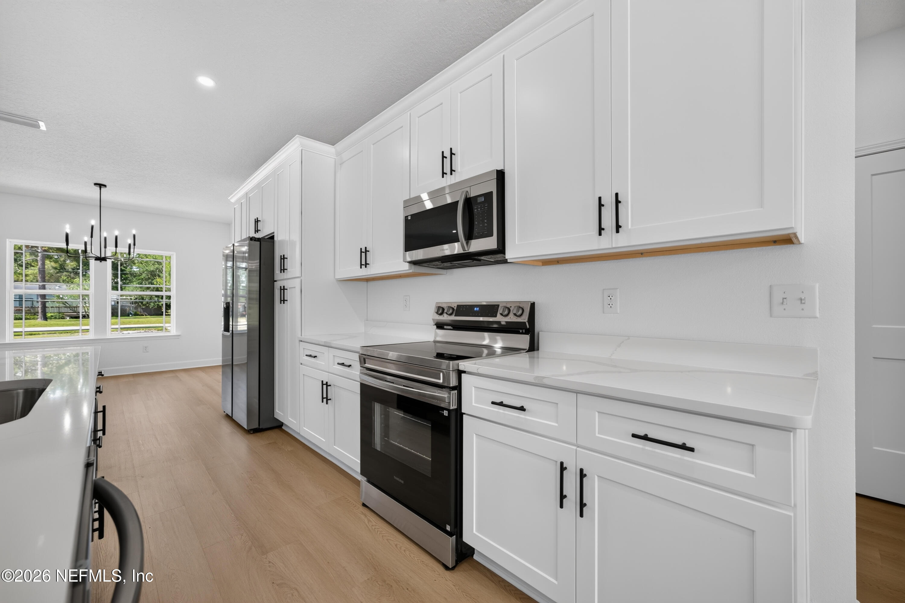 4362 Angora Street Middleburg, FL 32068 - Photo 6 of 31 a kitchen with stainless steel appliances granite countertop white cabinets and a stove top oven