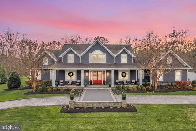 a front view of a house with a garden and lake view