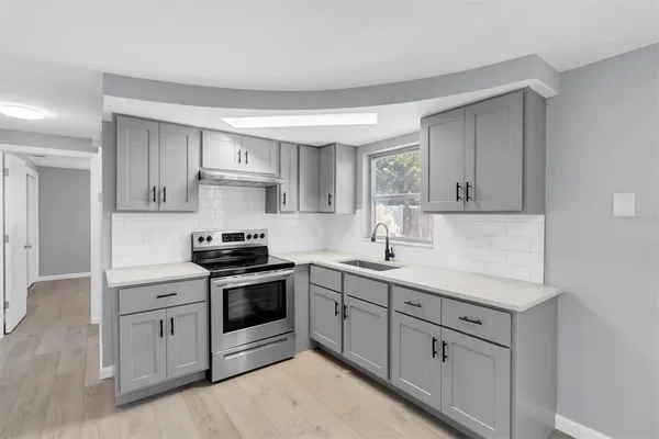 a kitchen with white cabinets stainless steel appliances and sink