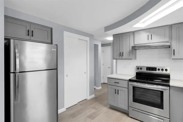 a kitchen with a refrigerator stove and white cabinets