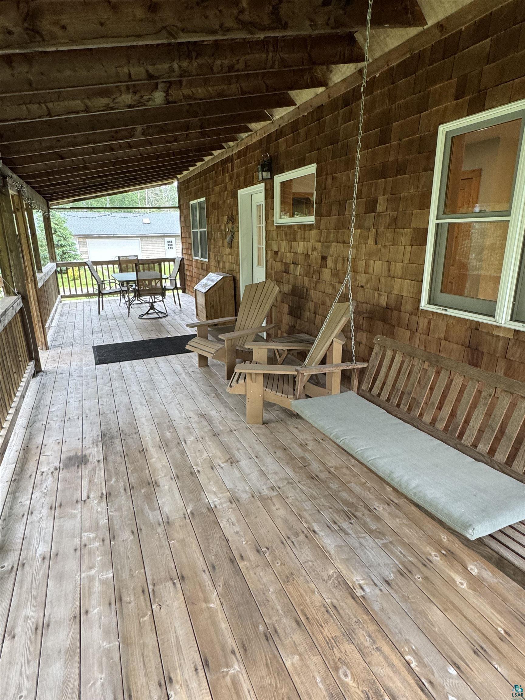 1745 Becks Road Maple, WI 54854 - Photo 5 of 46 Expansive covered porch featuring wood flooring, wood shingle siding, and white-framed windows
