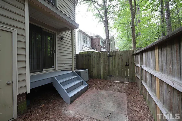 a view of a backyard with a large tree and wooden fence