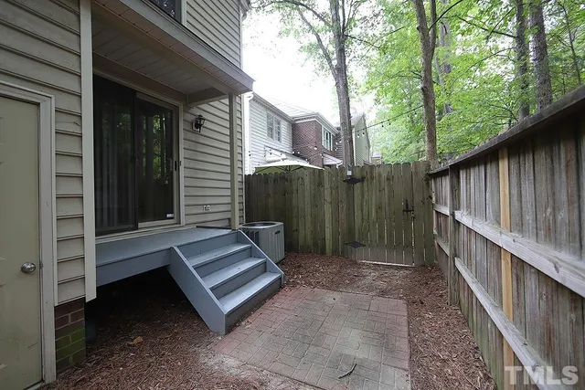 a view of a backyard with a large tree and wooden fence