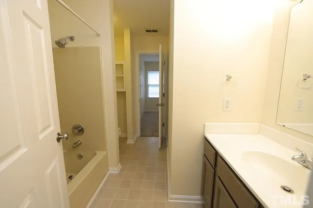 a bathroom with a tub shower vanity and a sink
