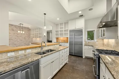 a bathroom with a granite countertop sink a mirror and shower