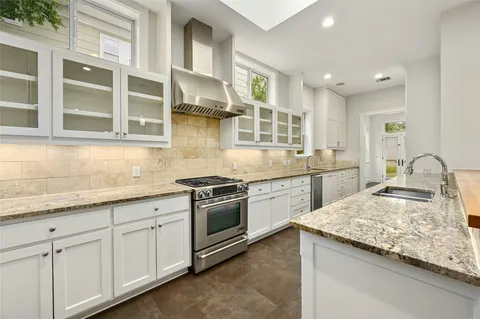 a large kitchen with stainless steel appliances granite countertop a lot of counter space and a sink