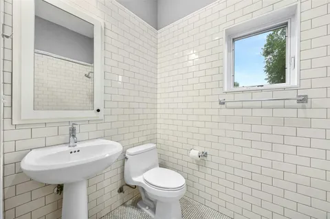 a bathroom with a granite countertop sink a toilet and a shower