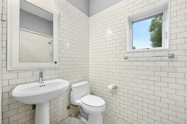 a bathroom with a granite countertop sink a toilet and a shower