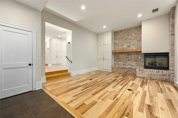 a view of empty room with wooden floor and windows